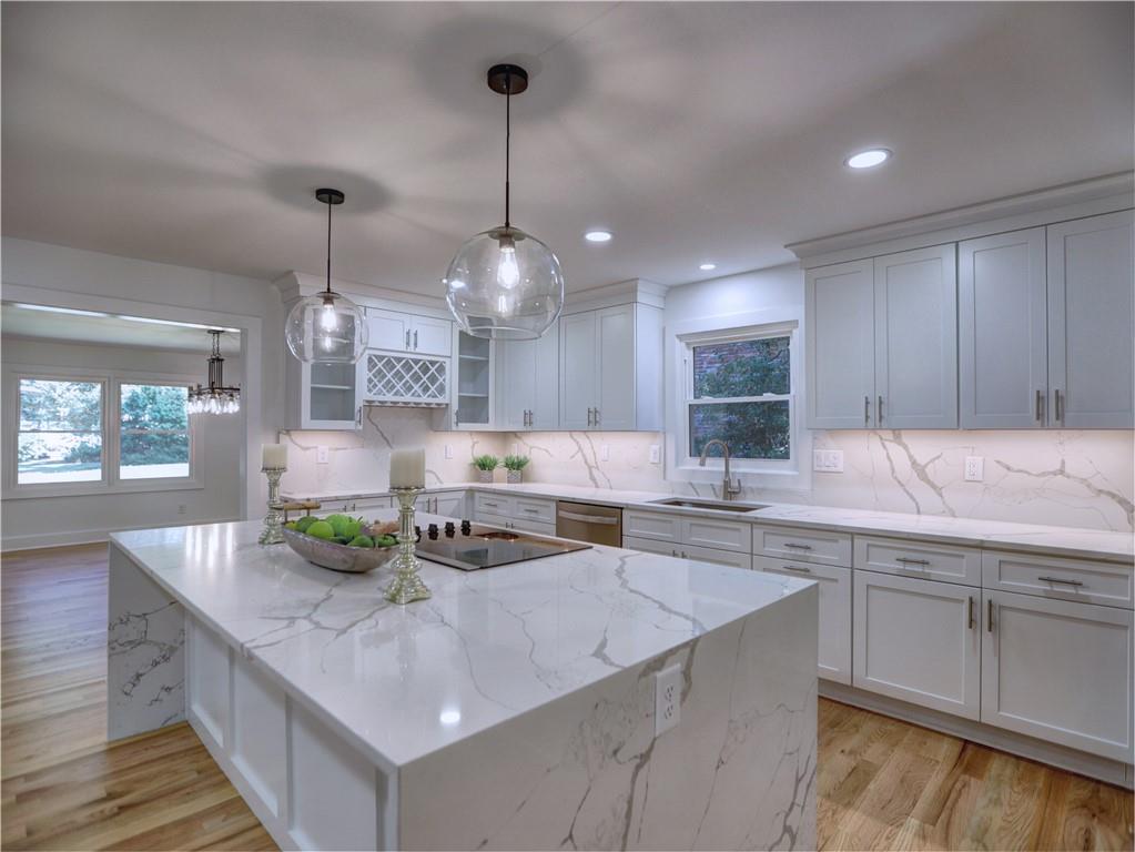 a kitchen with stainless steel appliances a sink a counter top space cabinets and wooden floor