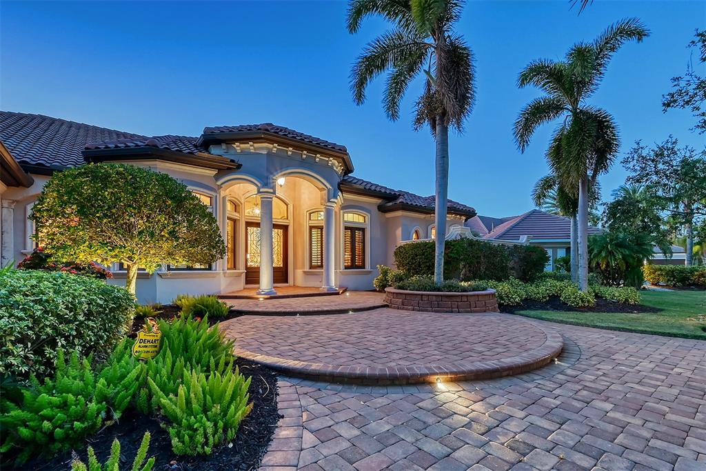 a view of a house with a yard plants and palm trees