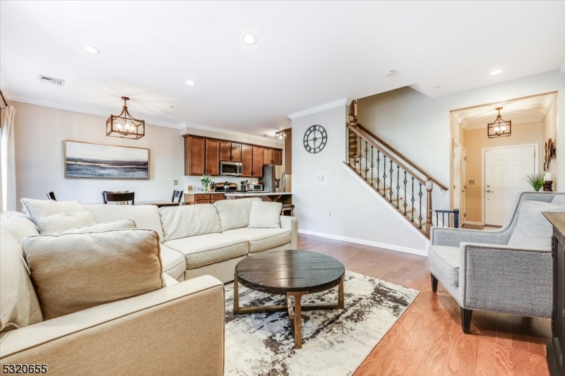 a living room with furniture and a dining table with wooden floor