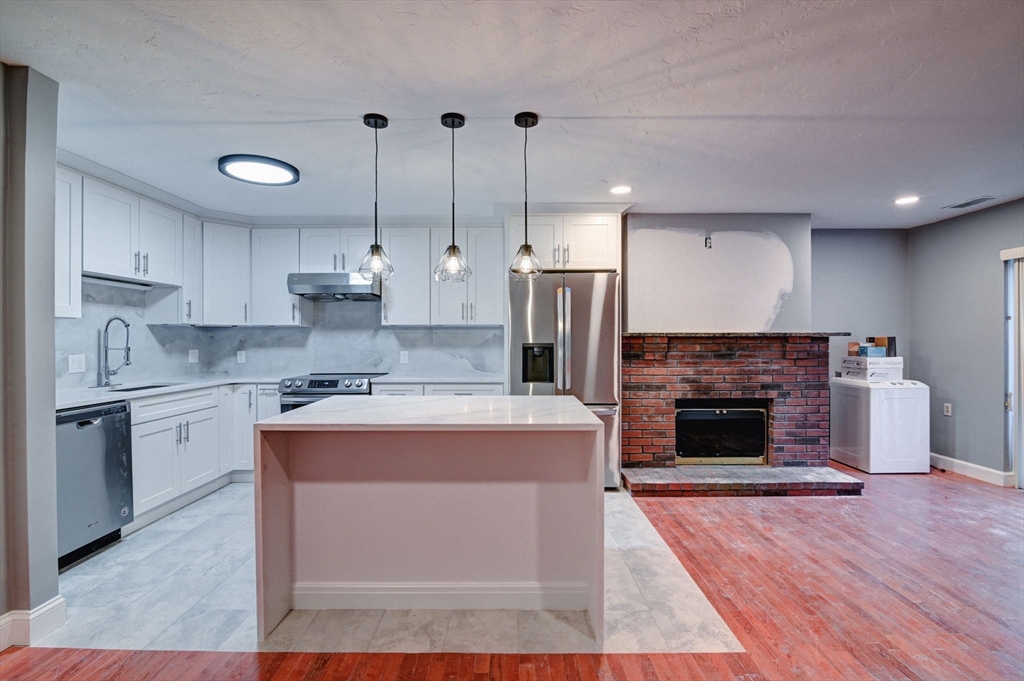 a kitchen with kitchen island a stove a sink and a refrigerator