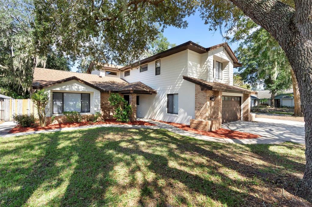 a view of a house with a yard and tree s