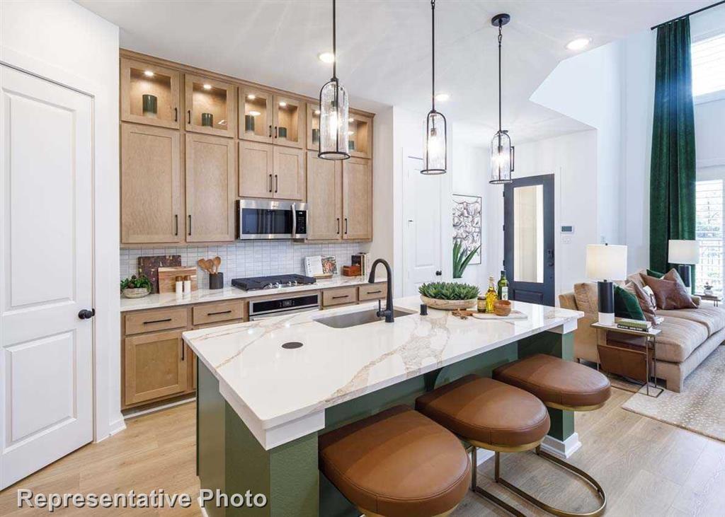 a kitchen with granite countertop a sink appliances and cabinets