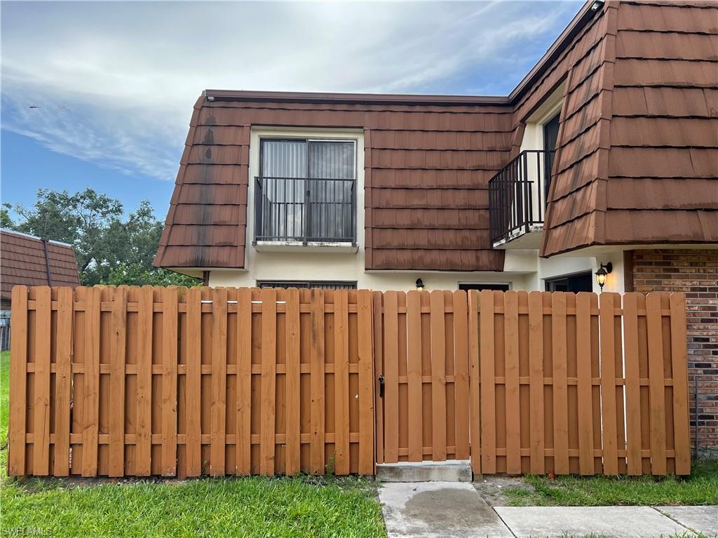 a view of a house with a wooden fence