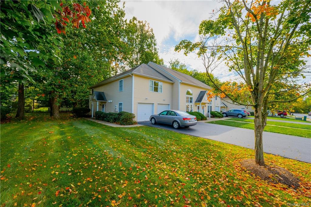 a view of a house with backyard and trees