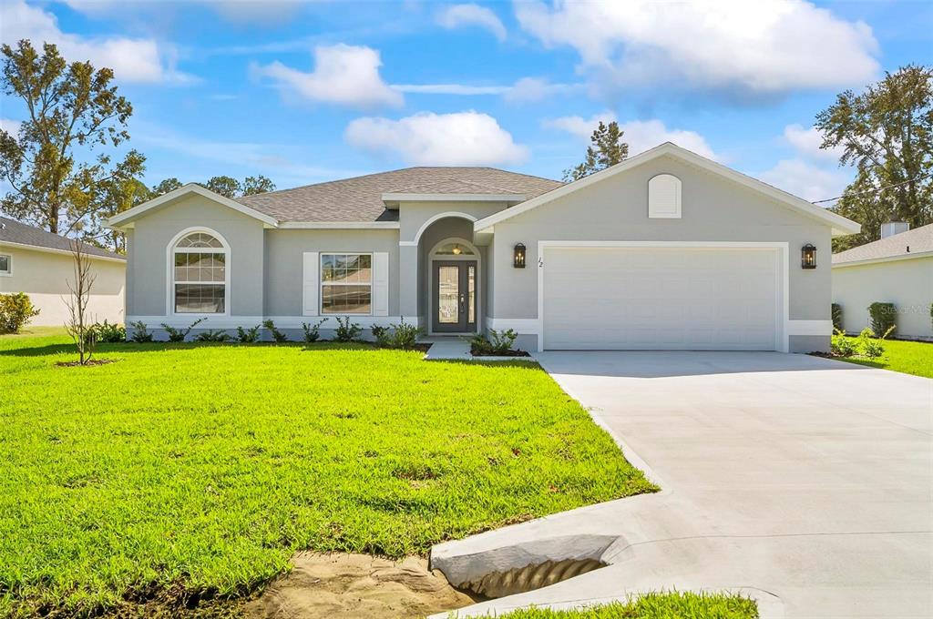 a front view of a house with yard and green space