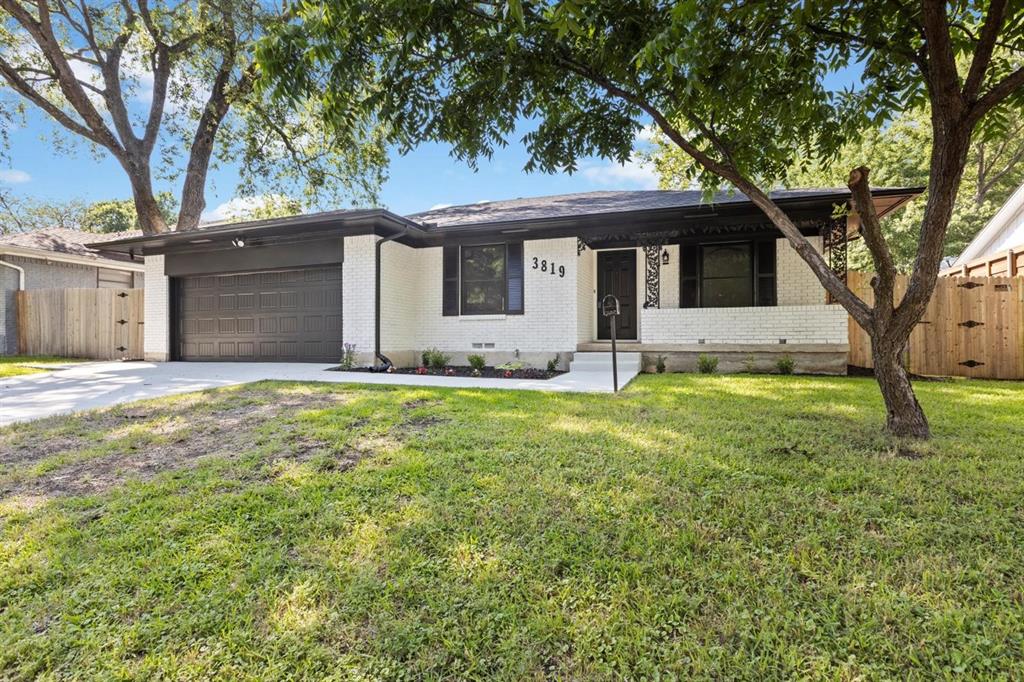 a front view of house with yard and trees around