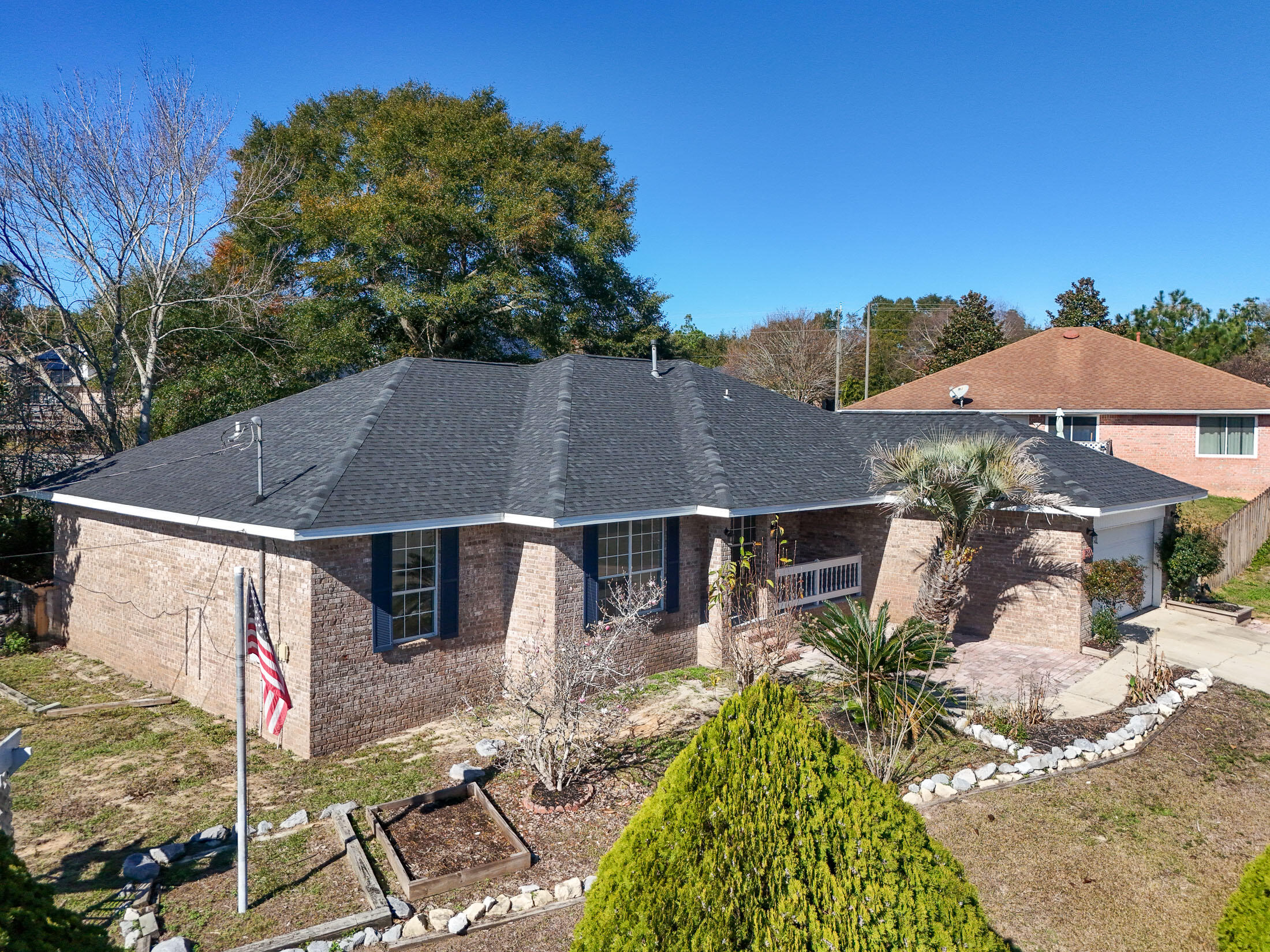 a aerial view of a house with table and chairs under an umbrella