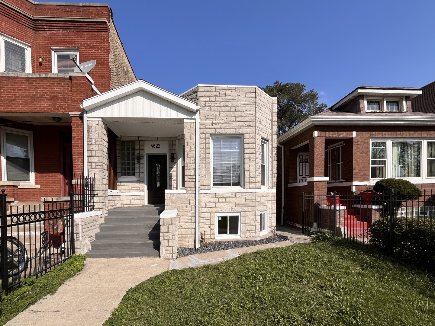 a front view of a house with yard and green space