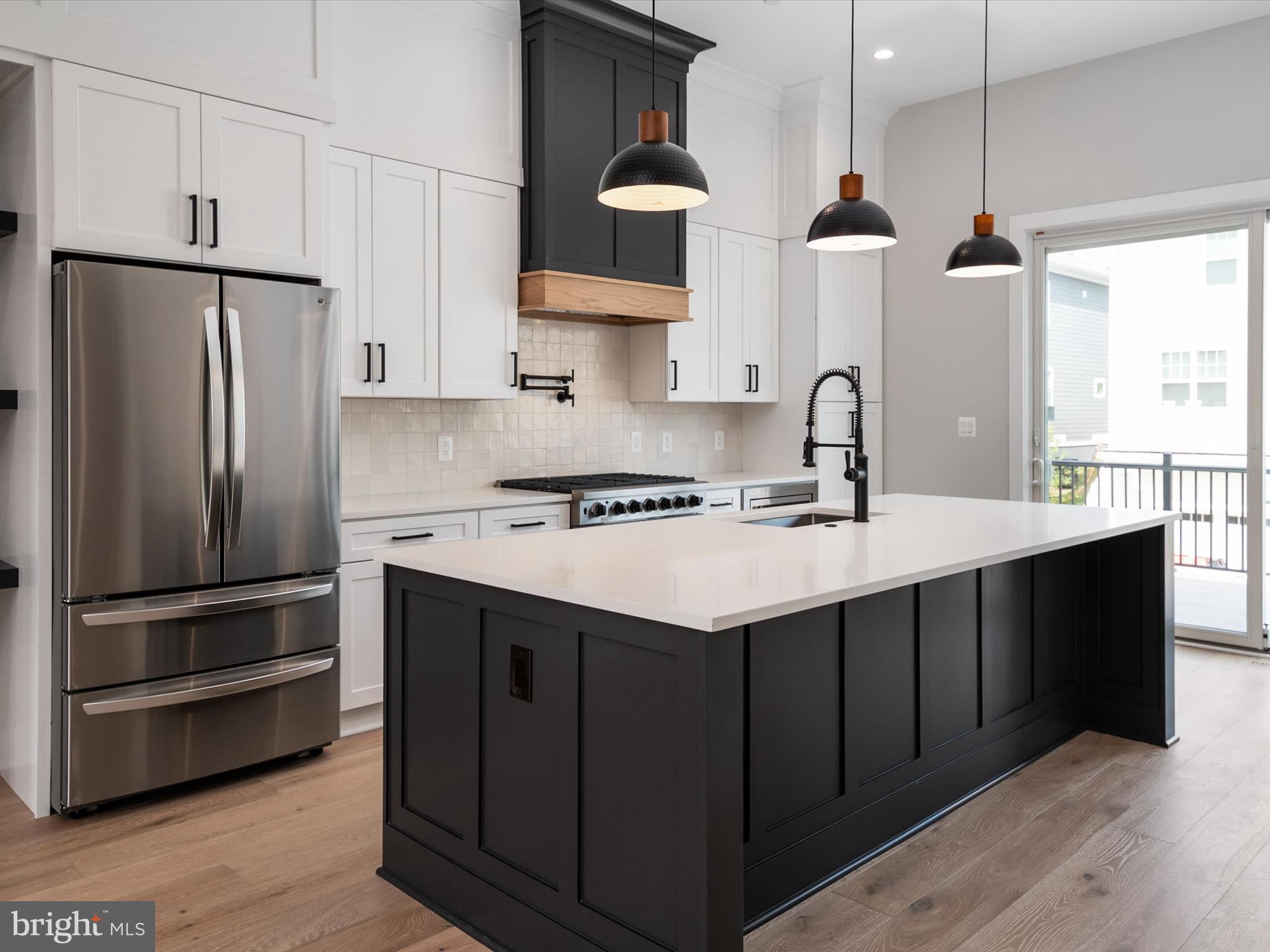 a kitchen with kitchen island granite countertop a sink stainless steel appliances and cabinets