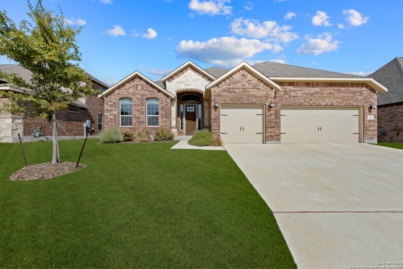 a front view of a house with a yard and trees