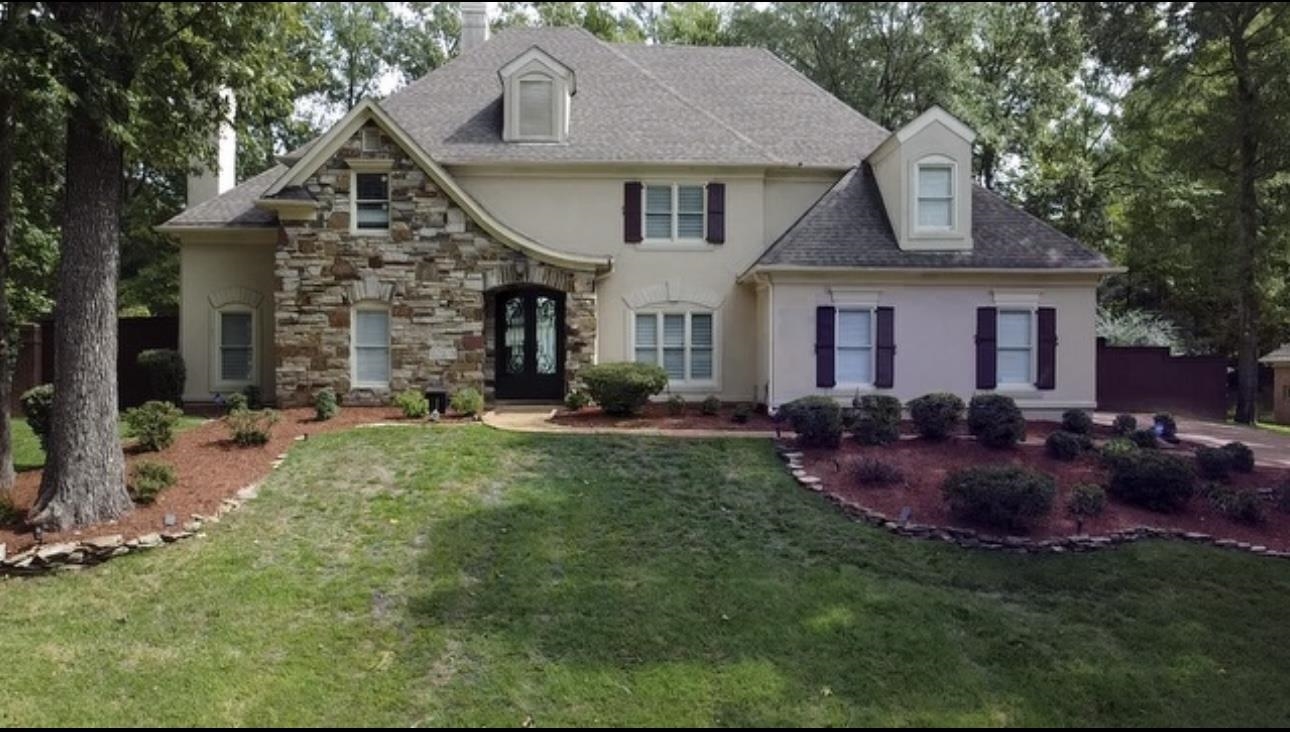 a front view of a house with a garden