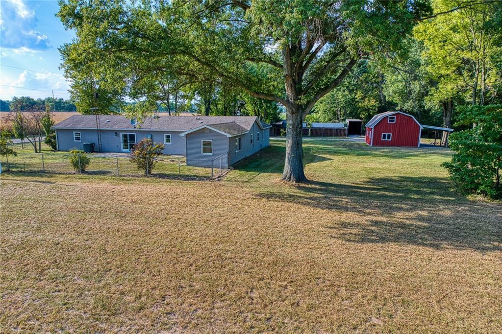 a view of backyard with wooden fence and large trees