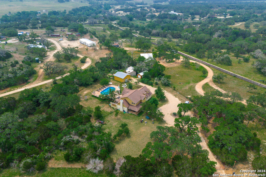 an aerial view of residential houses with outdoor space and trees