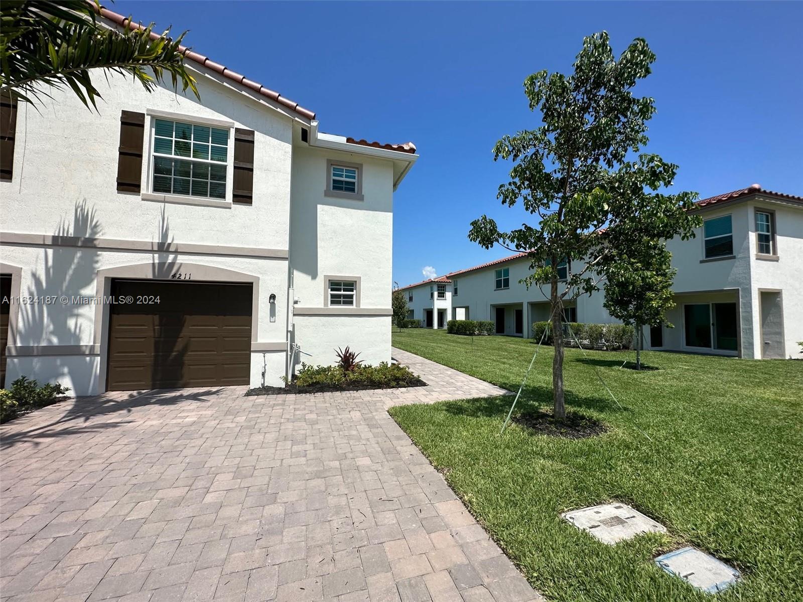 a front view of a house with a yard and garage