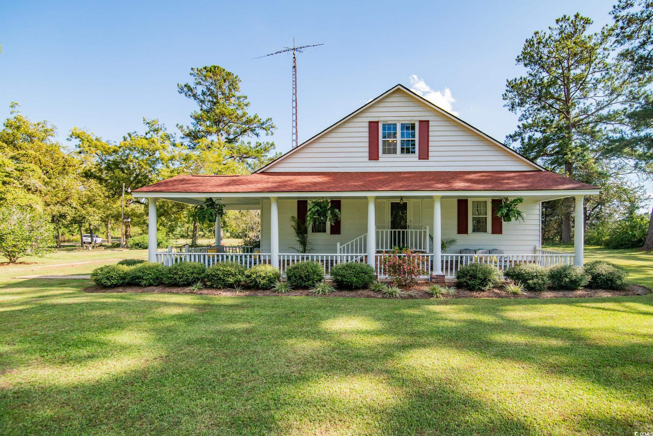 Farmhouse-style home with covered porch and a fron