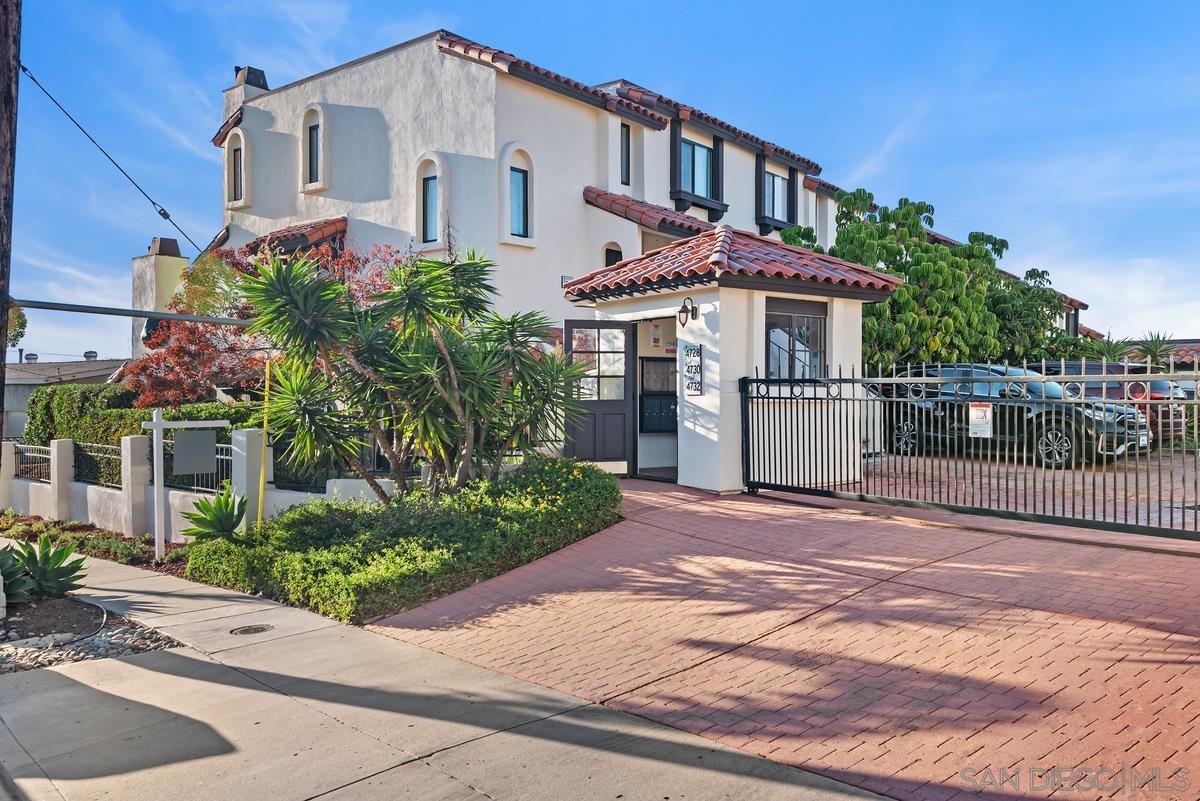 a front view of a house with a yard and potted plants