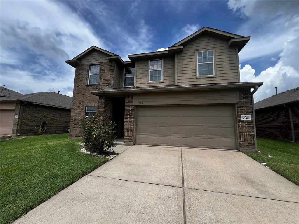 a front view of a house with a yard and garage