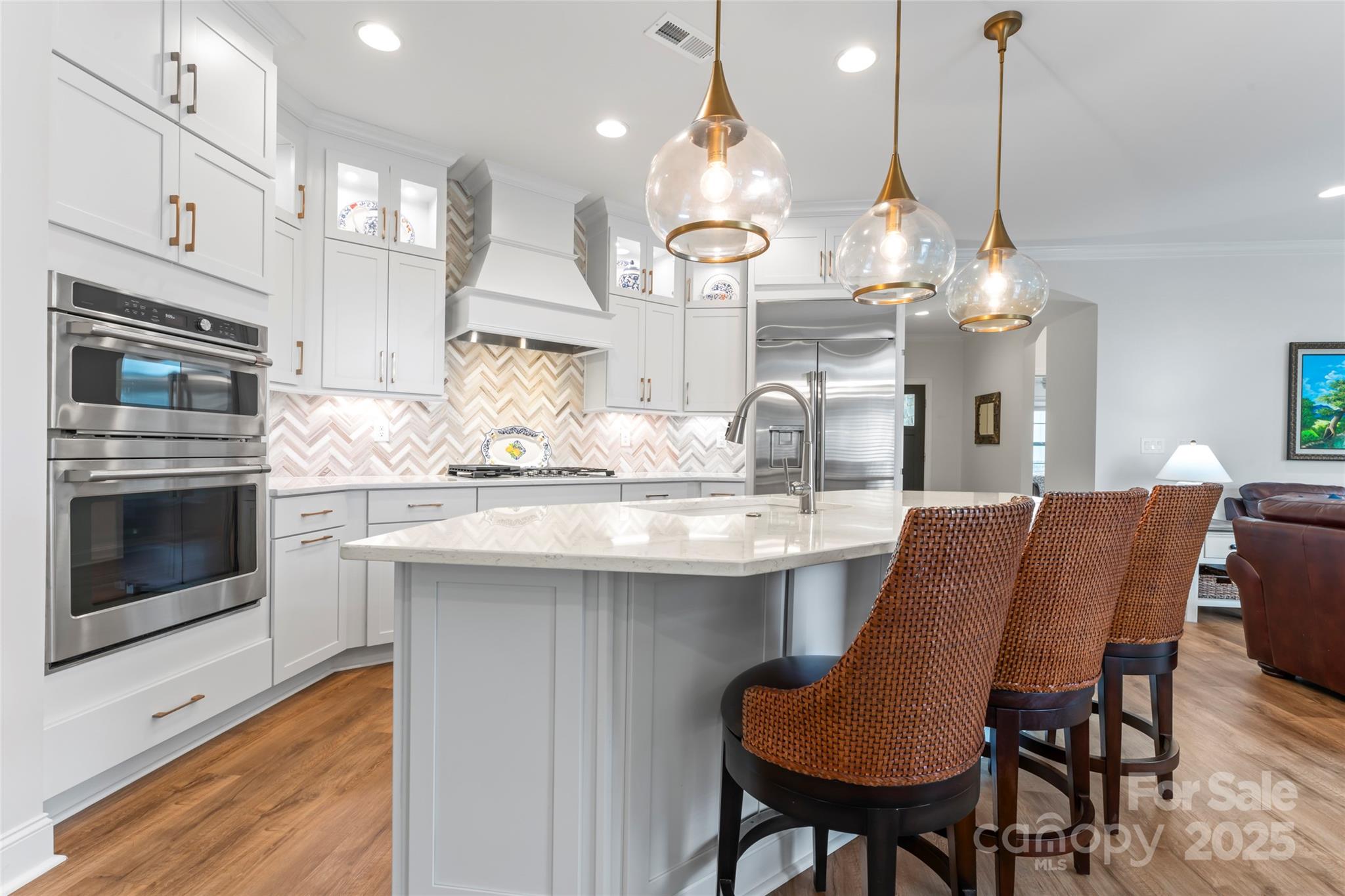 a kitchen with stainless steel appliances kitchen island granite countertop a table chairs and a chandelier