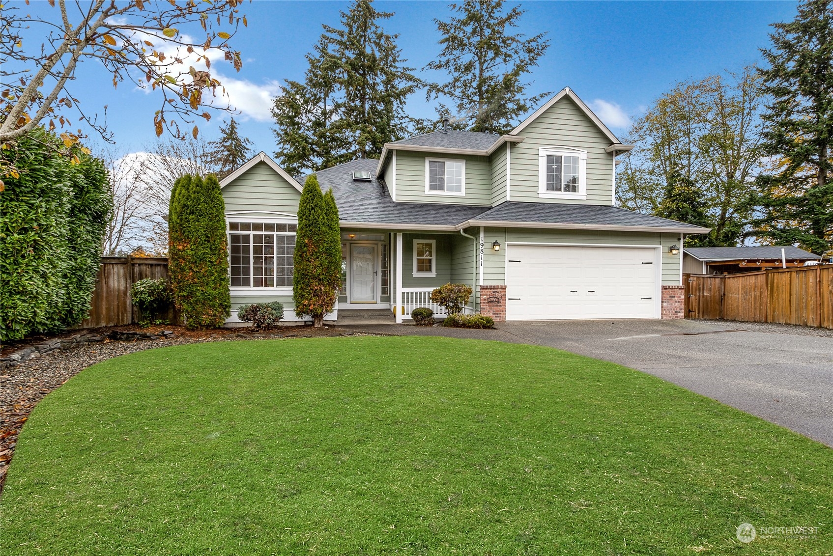 a front view of a house with a yard and trees