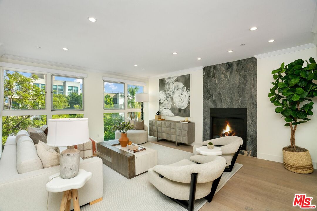 a living room with furniture fireplace and potted plants