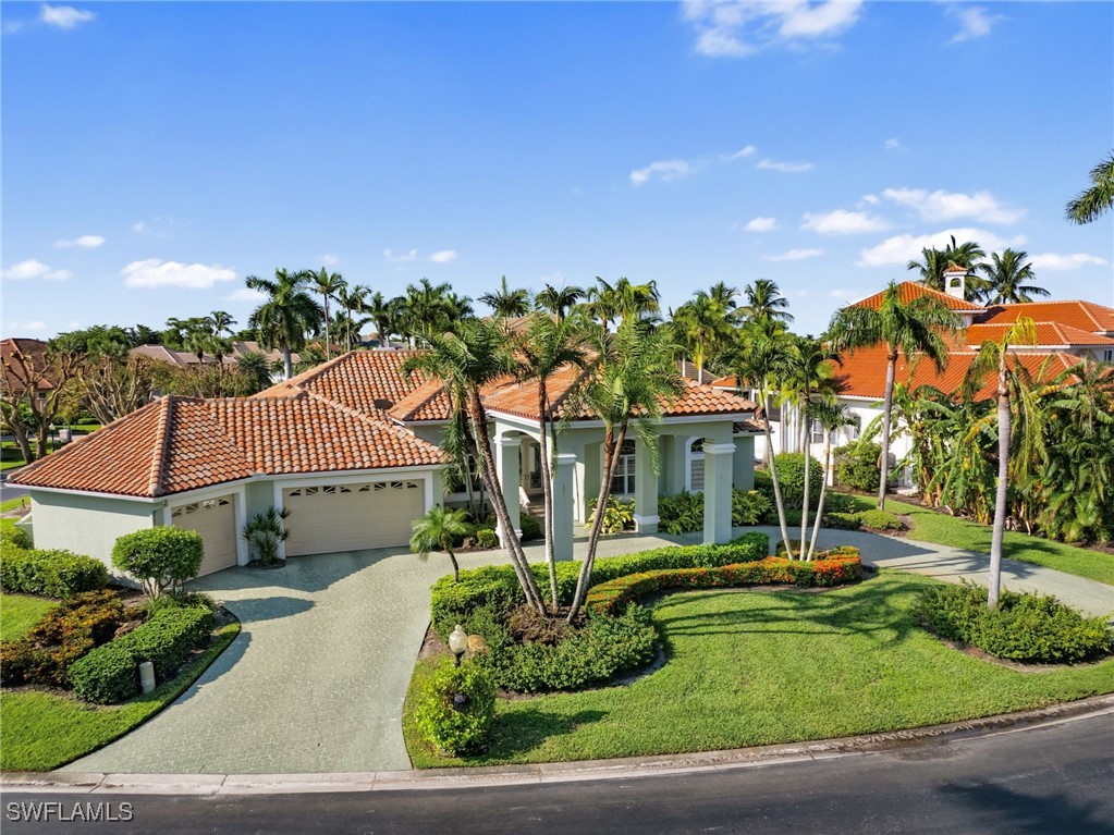 a front view of a house with a yard and potted plants