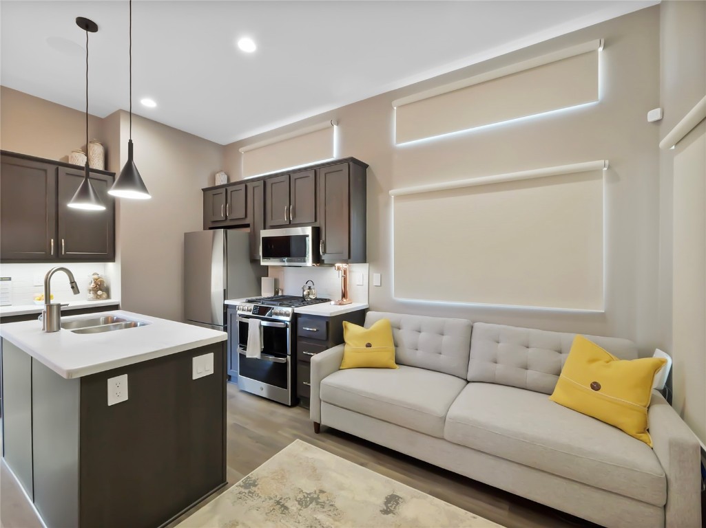 a living room with stainless steel appliances kitchen island furniture and a view of kitchen