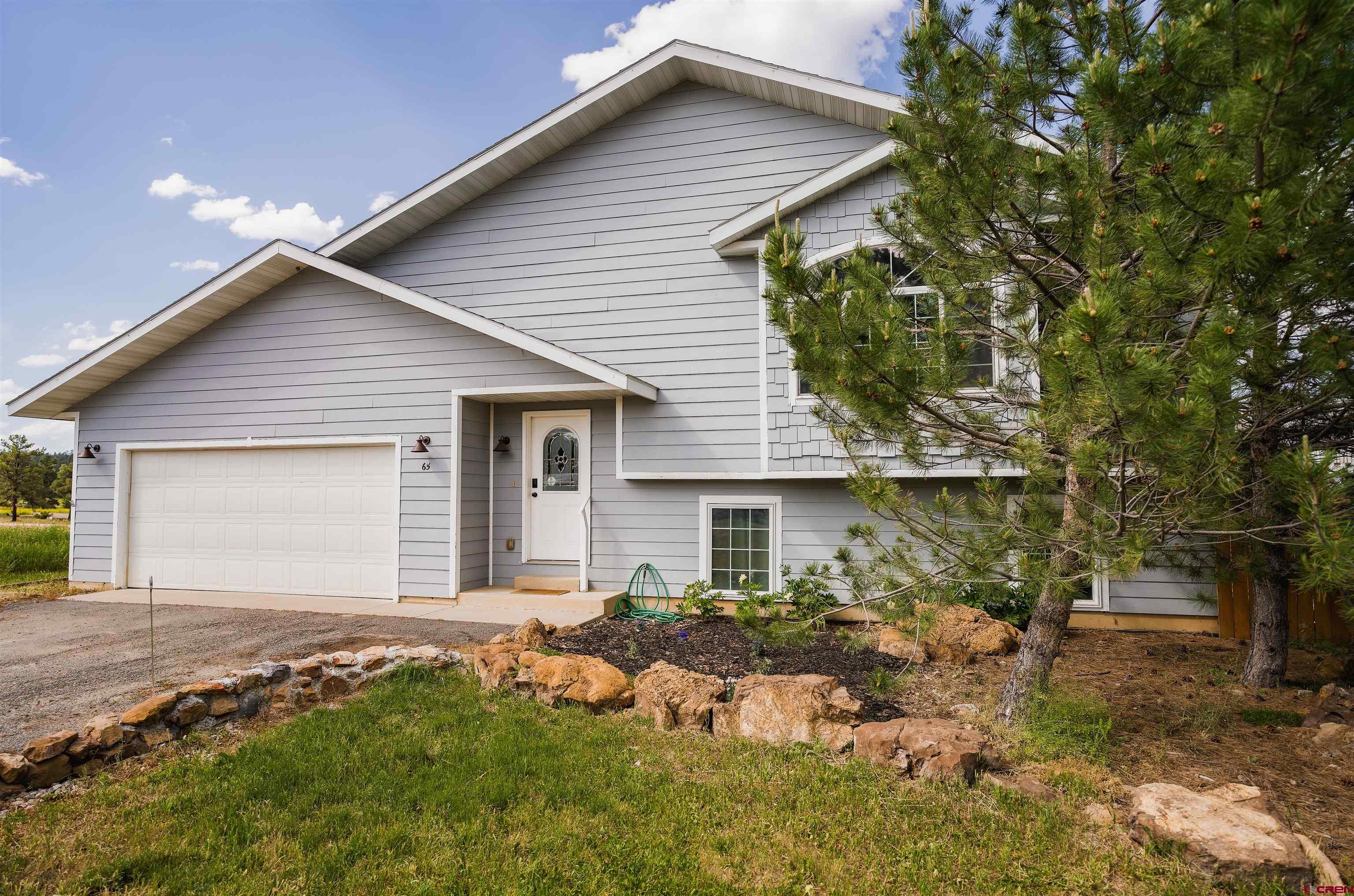 a front view of house with yard and trees around