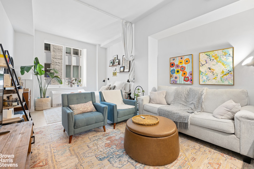 a living room with furniture and a painting on the wall