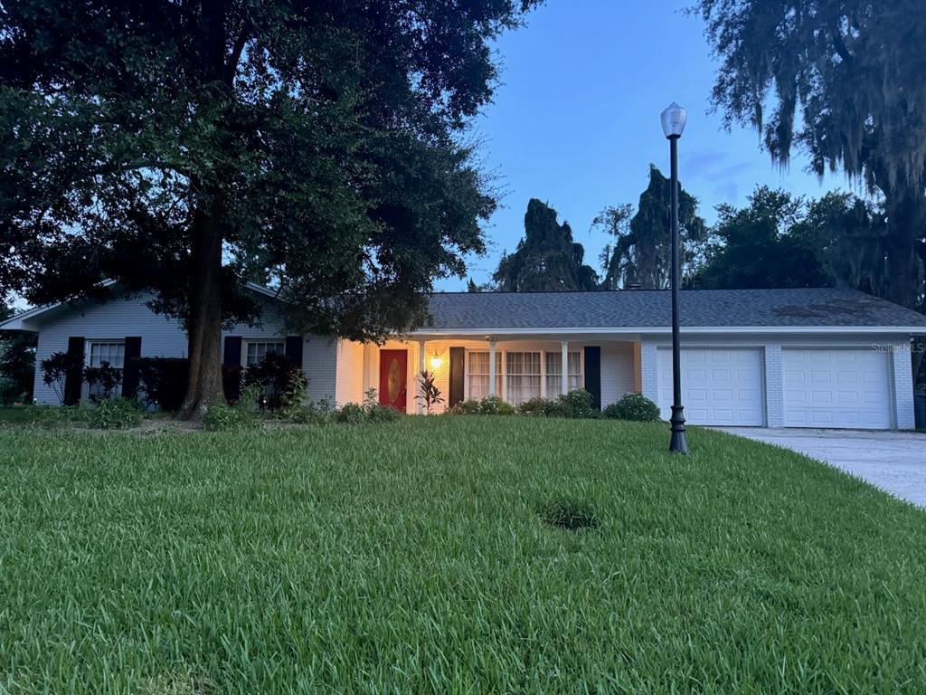 a front view of a house with a yard and trees