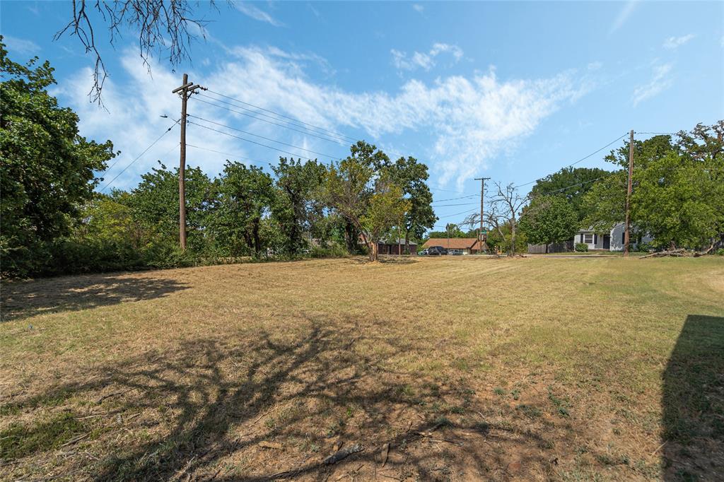 a view of a field with large trees