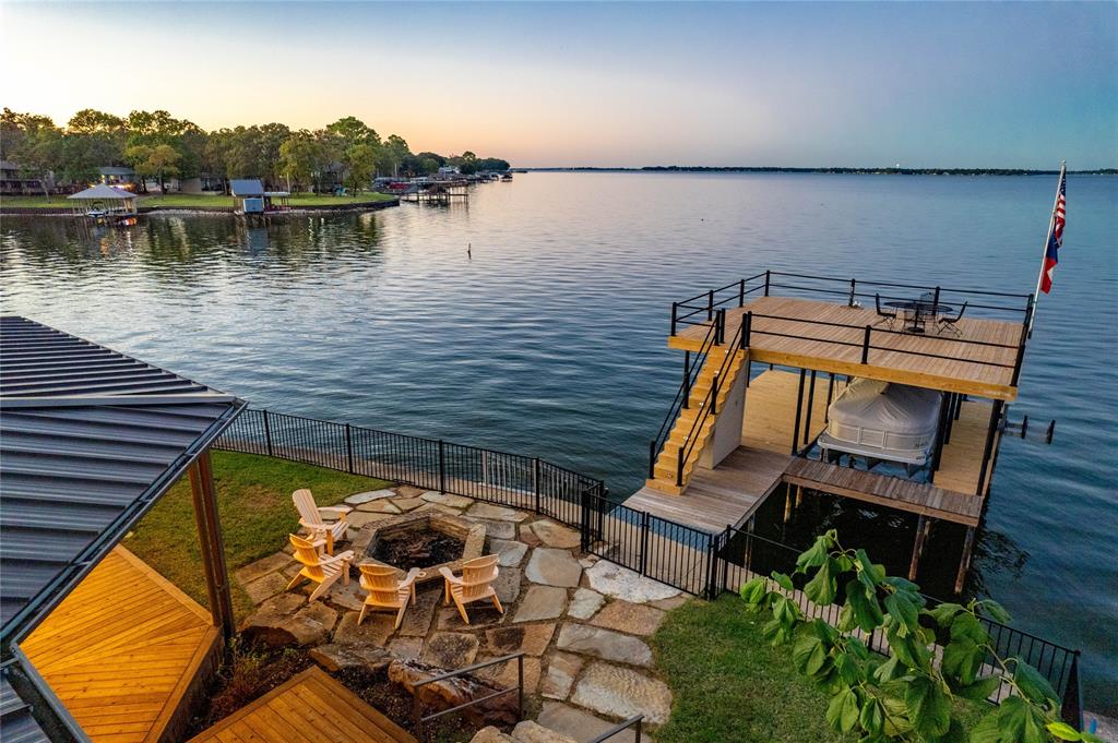 a view of a lake with couches chairs and wooden floor