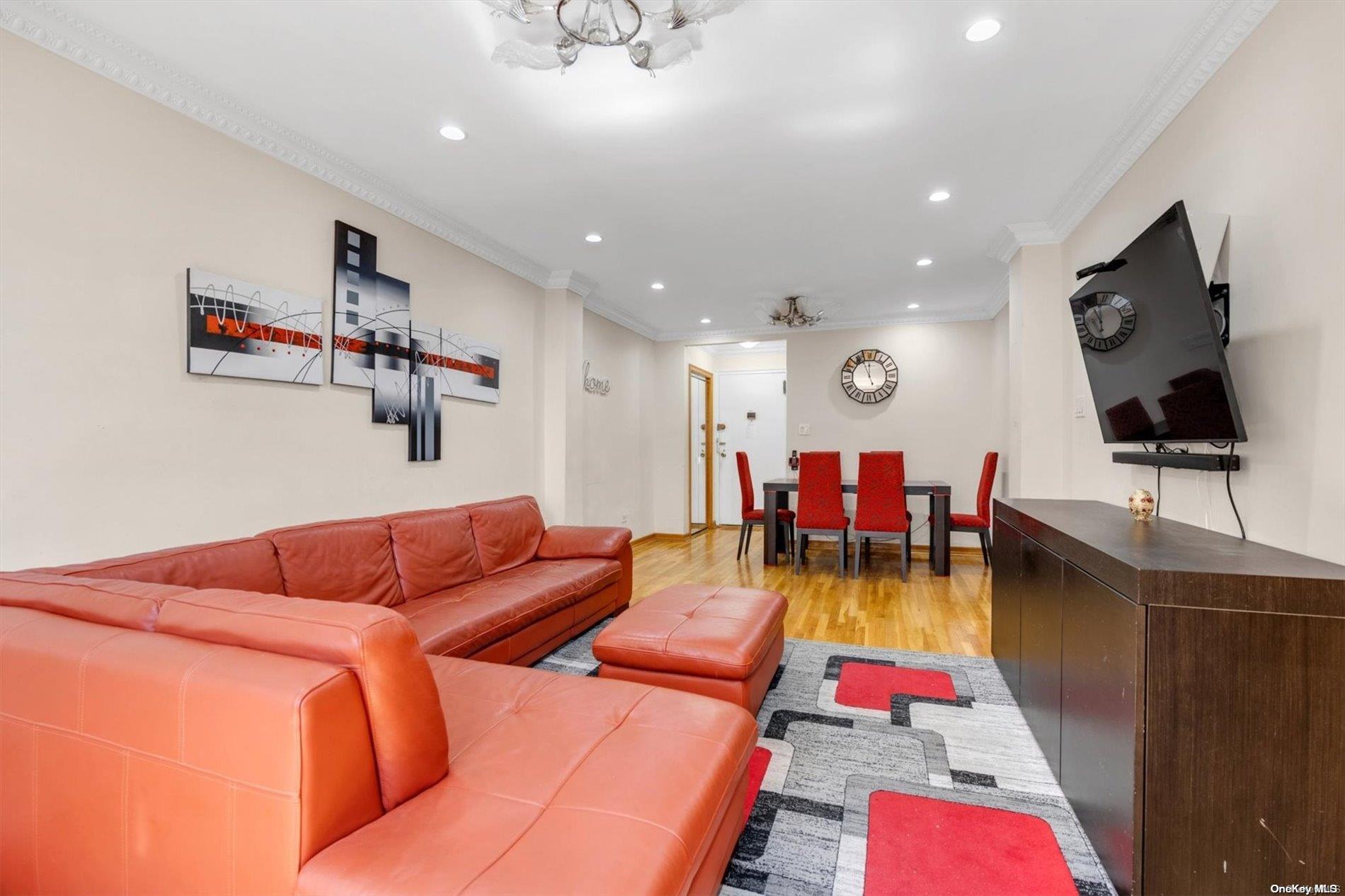 a living room with furniture kitchen view and a flat screen tv