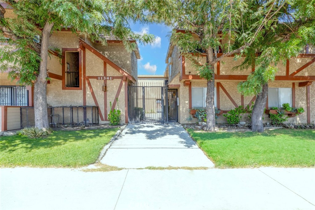 front view of house with a yard and potted plants