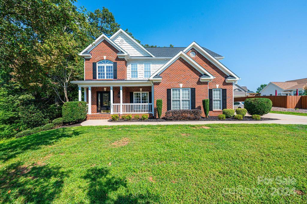 a front view of a house with yard and green space