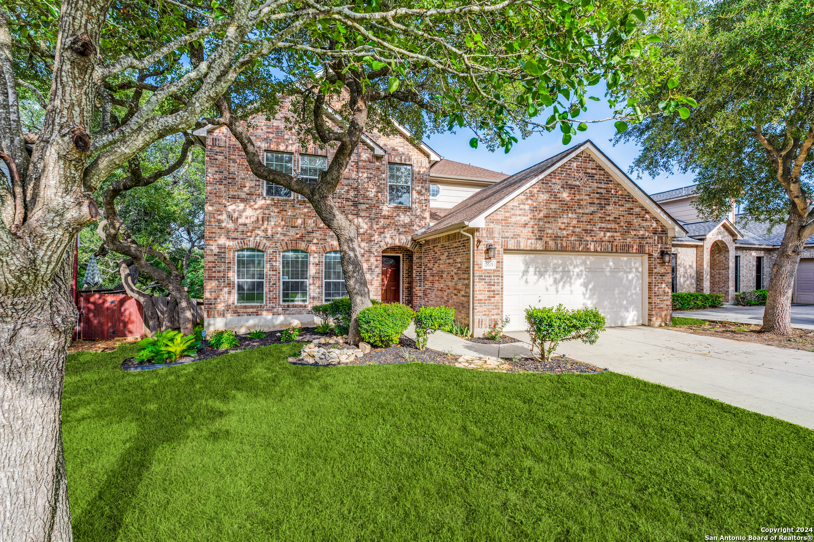 a front view of a house with a yard and trees