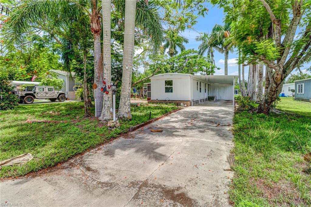 a front view of a house with a yard and a tree