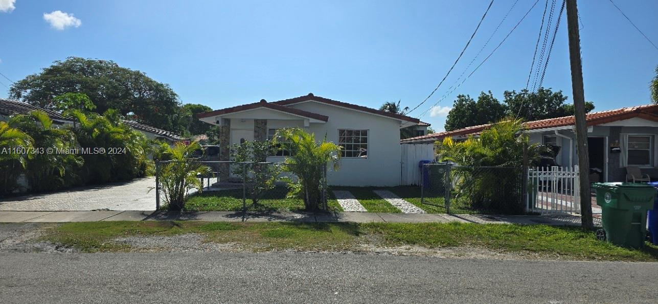 a view of house with a yard and potted plants