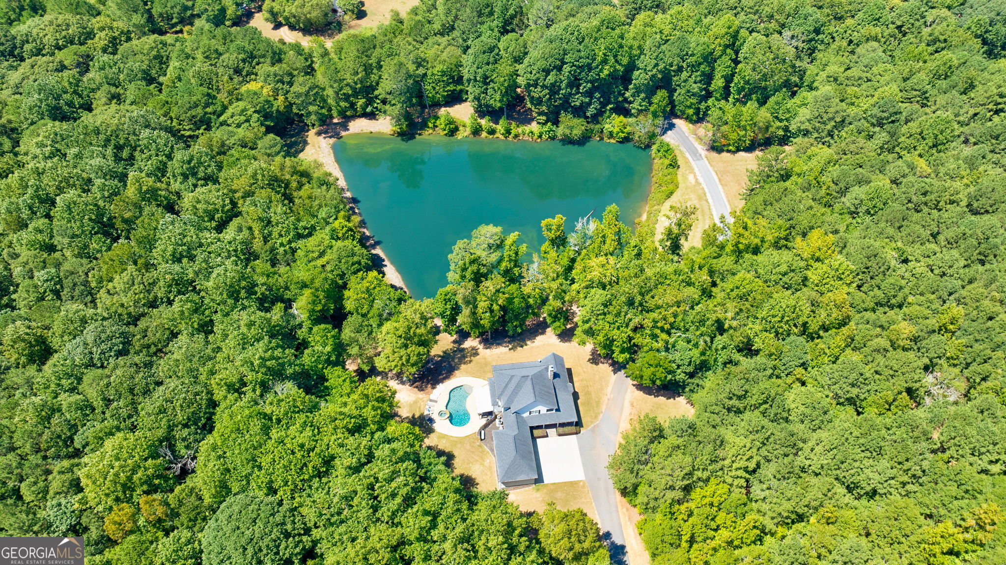 an aerial view of a house with a yard and lake view