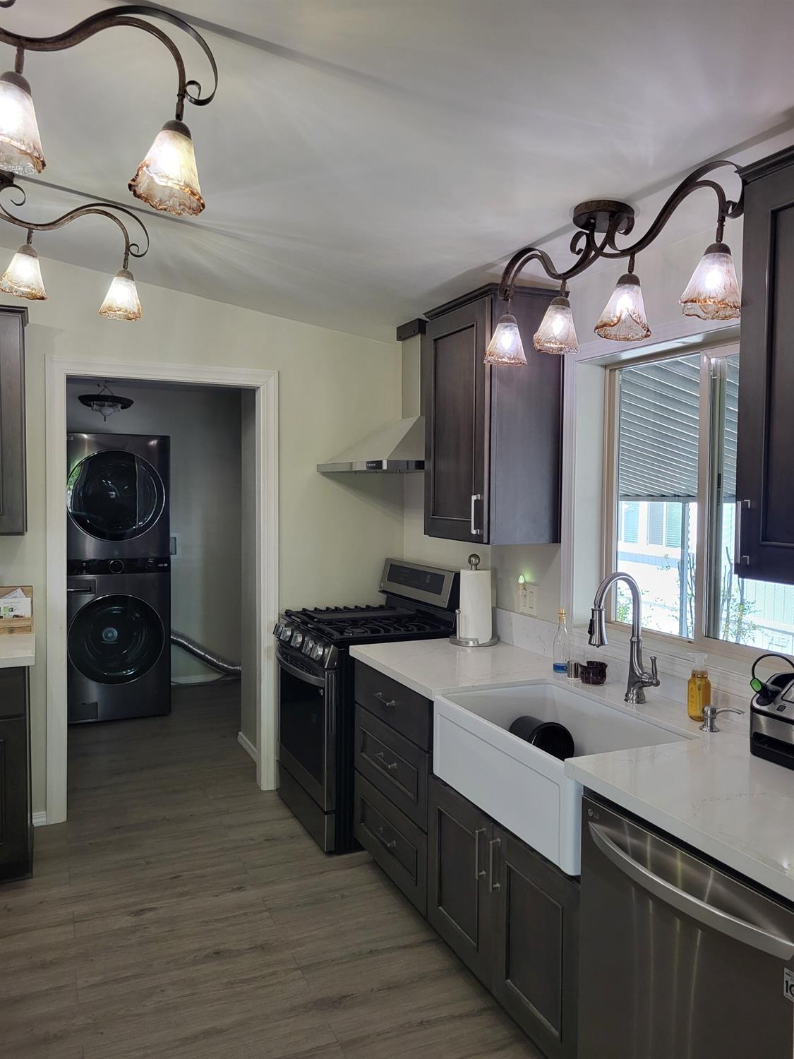 a kitchen with a sink dishwasher a stove and a refrigerator with wooden floor