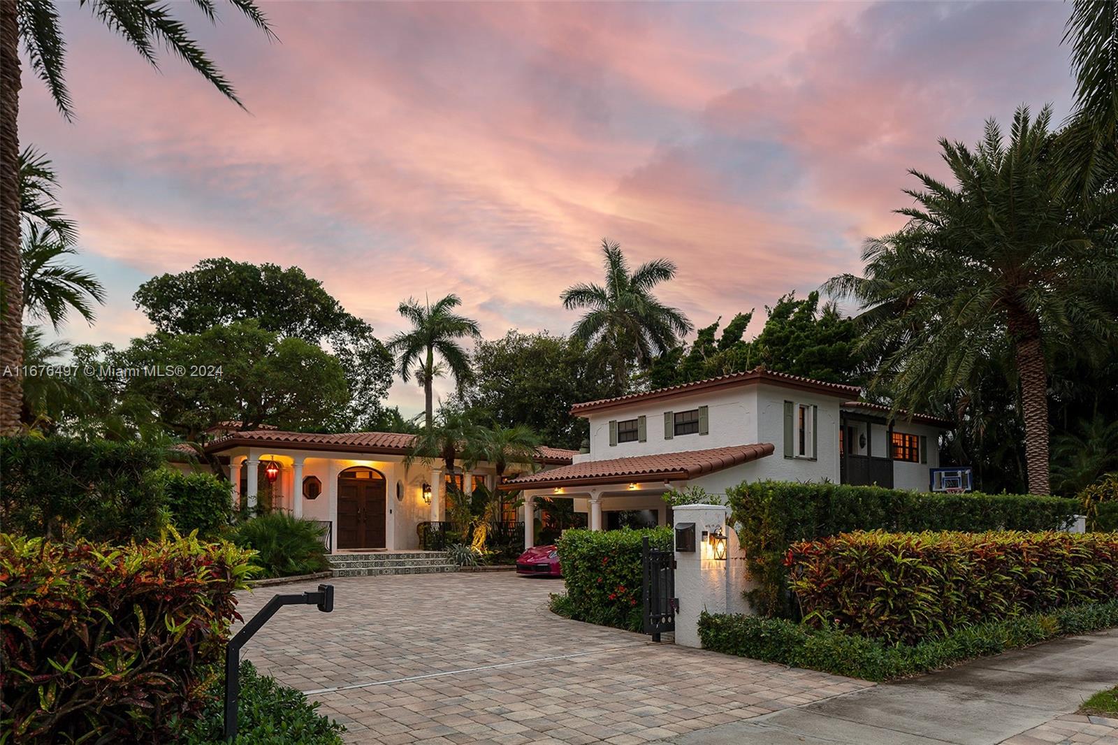 Spanish Colonial elegance with lush gardens and gated entrance.