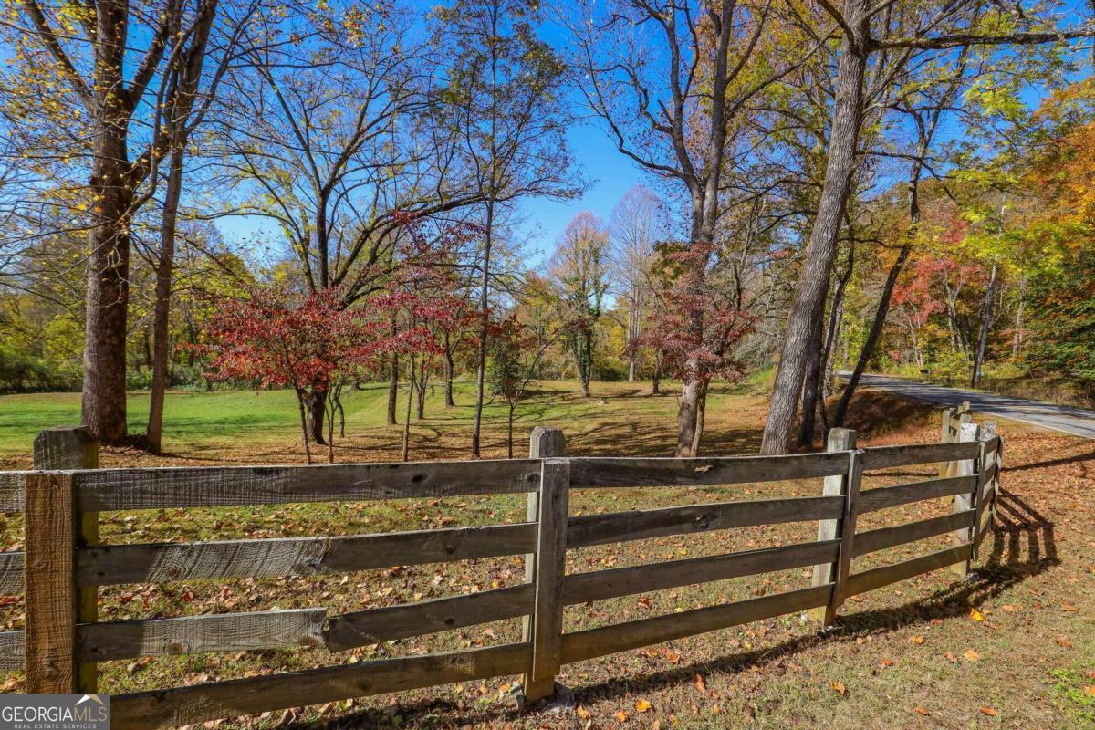 a view of a yard with wooden fence