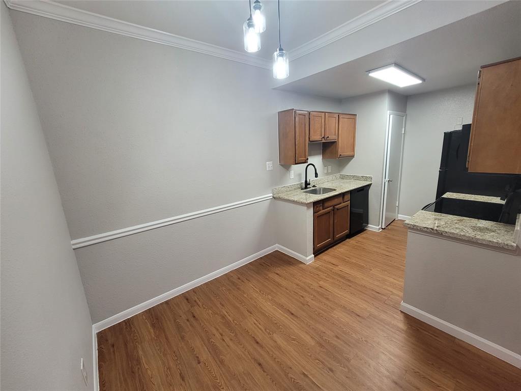 a kitchen with granite countertop a sink cabinets and stainless steel appliances