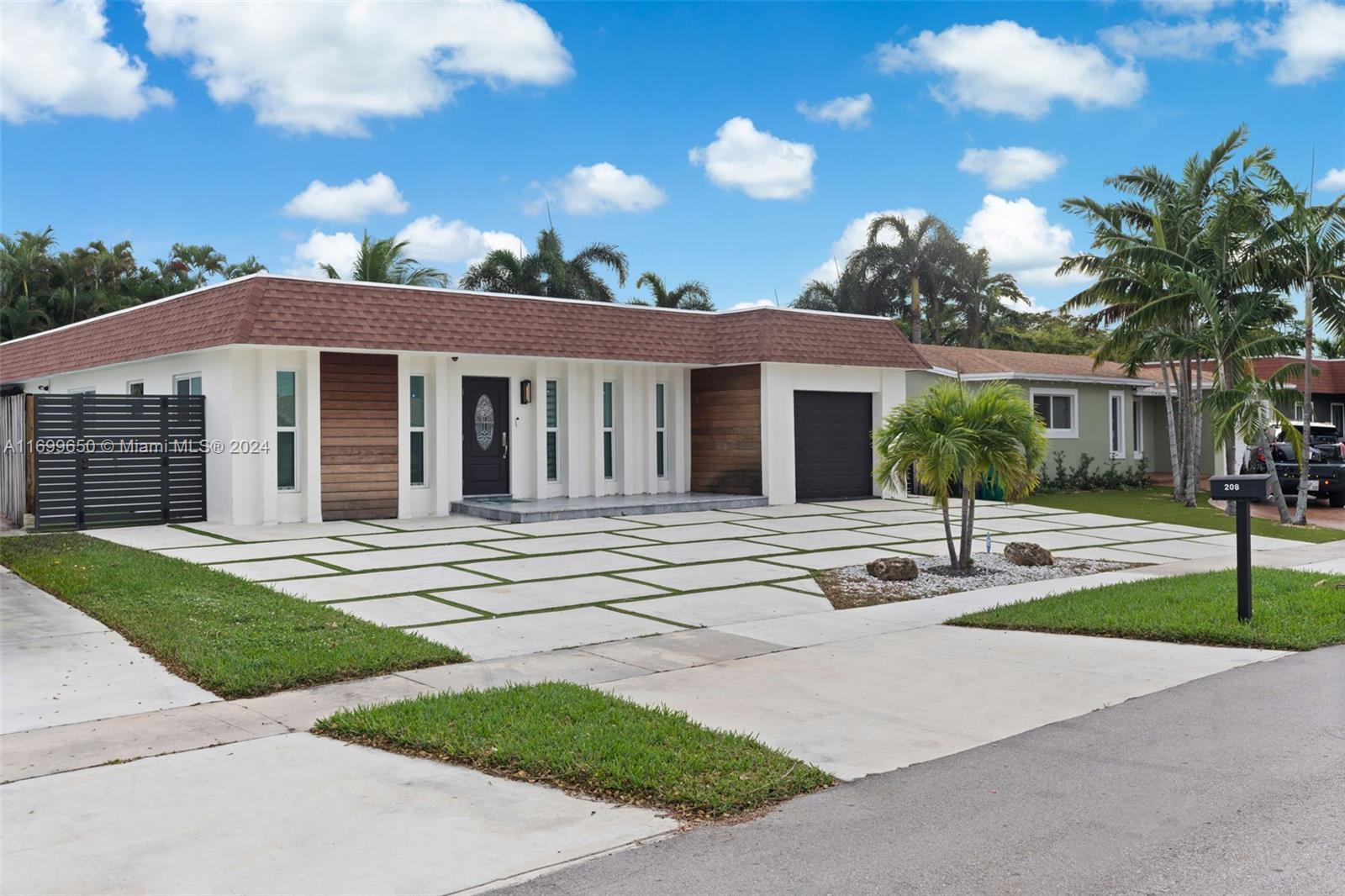 a front view of a house with a yard and potted plants