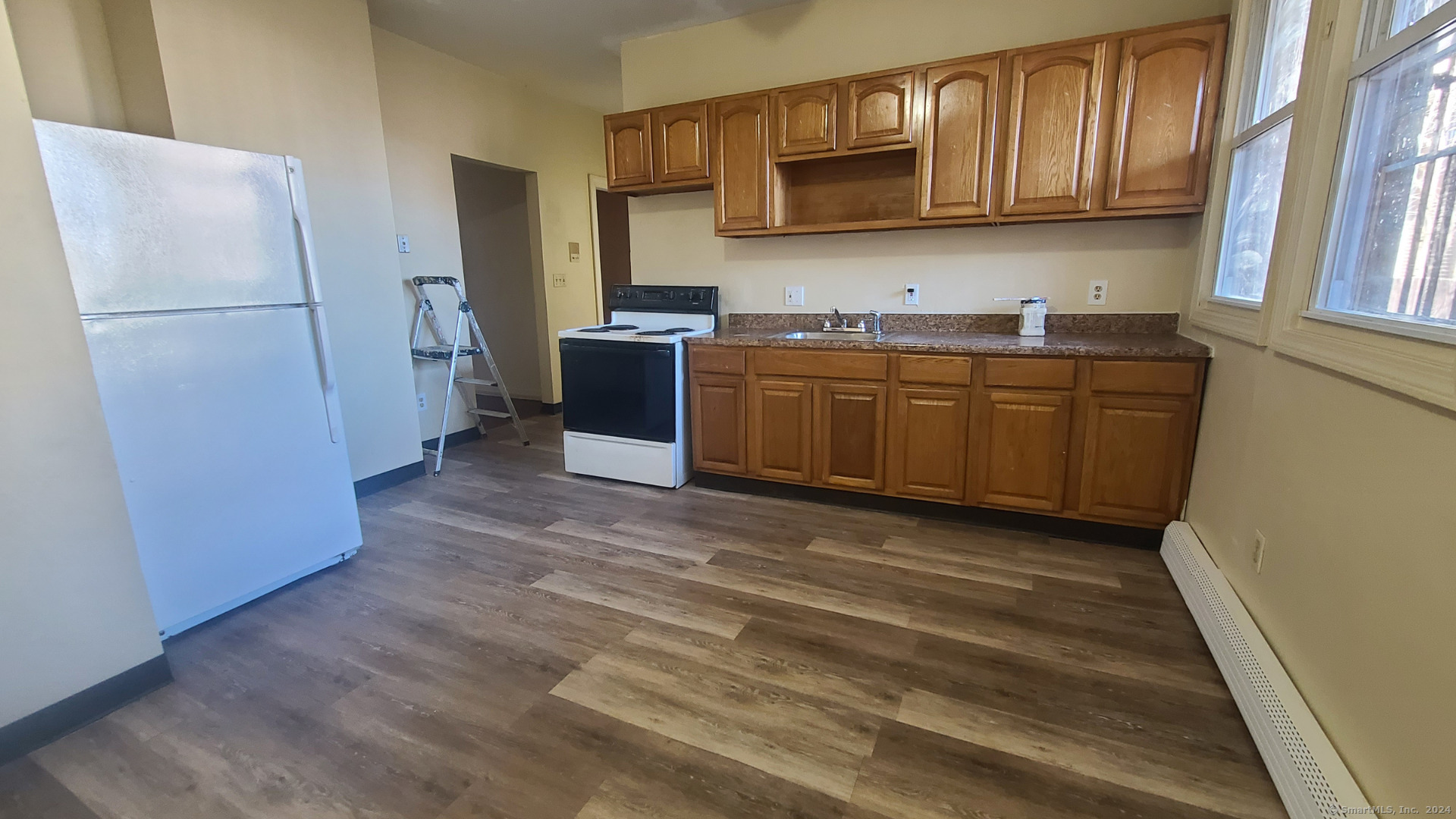 a kitchen with stainless steel appliances granite countertop a refrigerator and a stove top oven