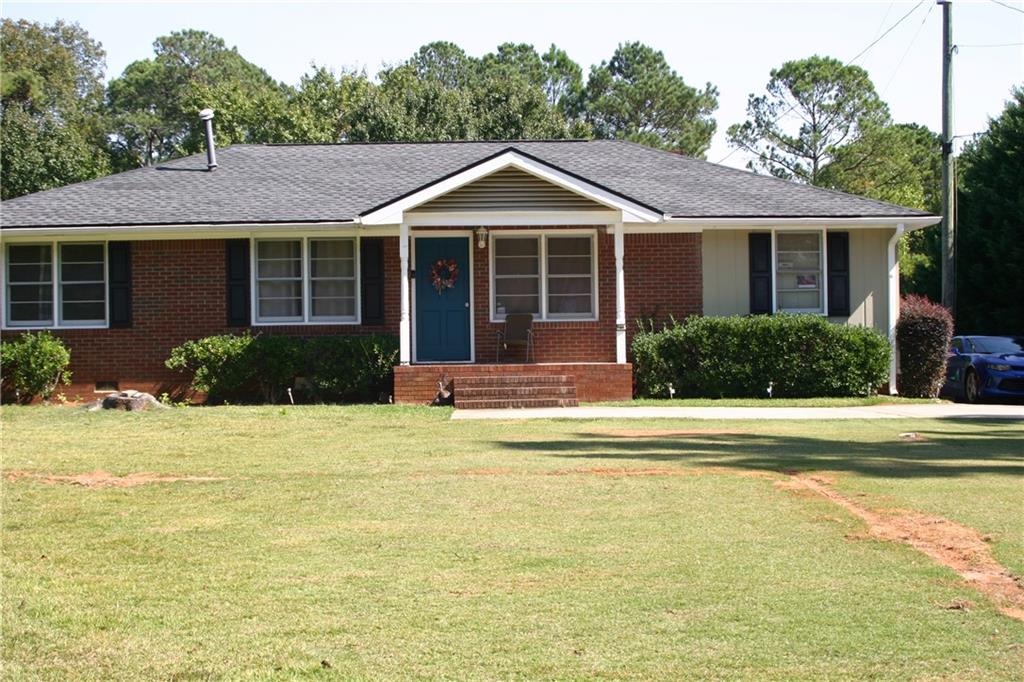 a front view of a house with a yard and potted plants