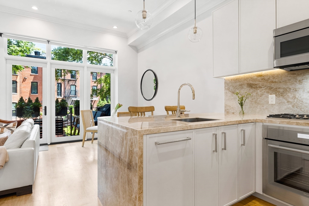 a kitchen with kitchen island granite countertop a stove and a sink with granite countertops