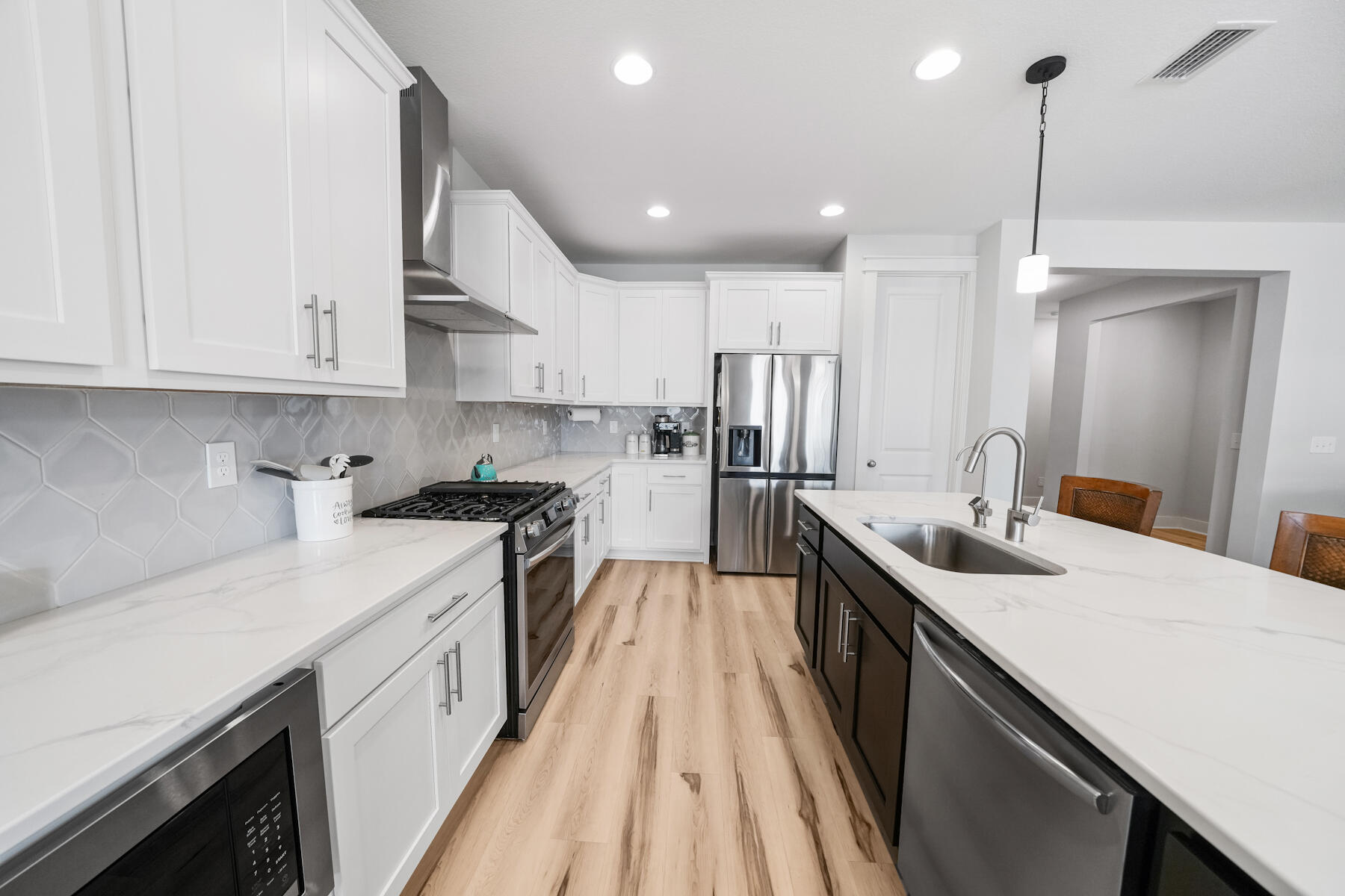 a kitchen with white cabinets sink and stainless steel appliances