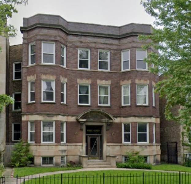 a front view of a residential apartment building with a yard