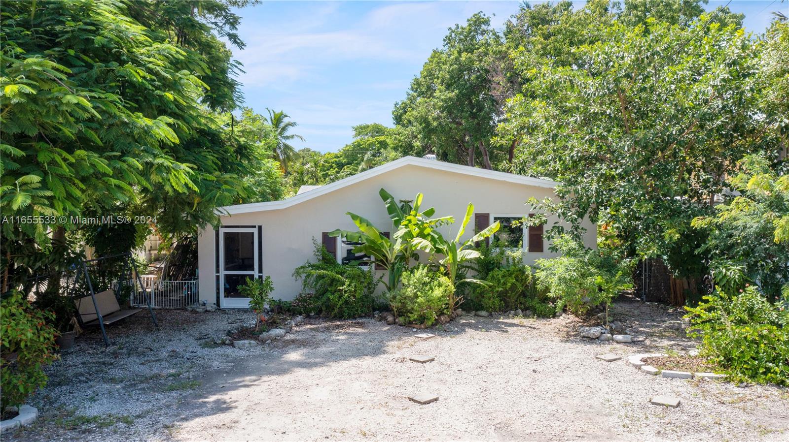 a backyard of a house with plants and tree