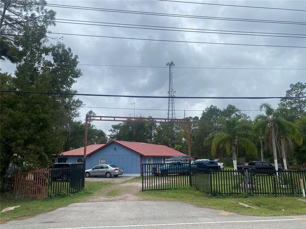 a view of a house with a yard and potted plants